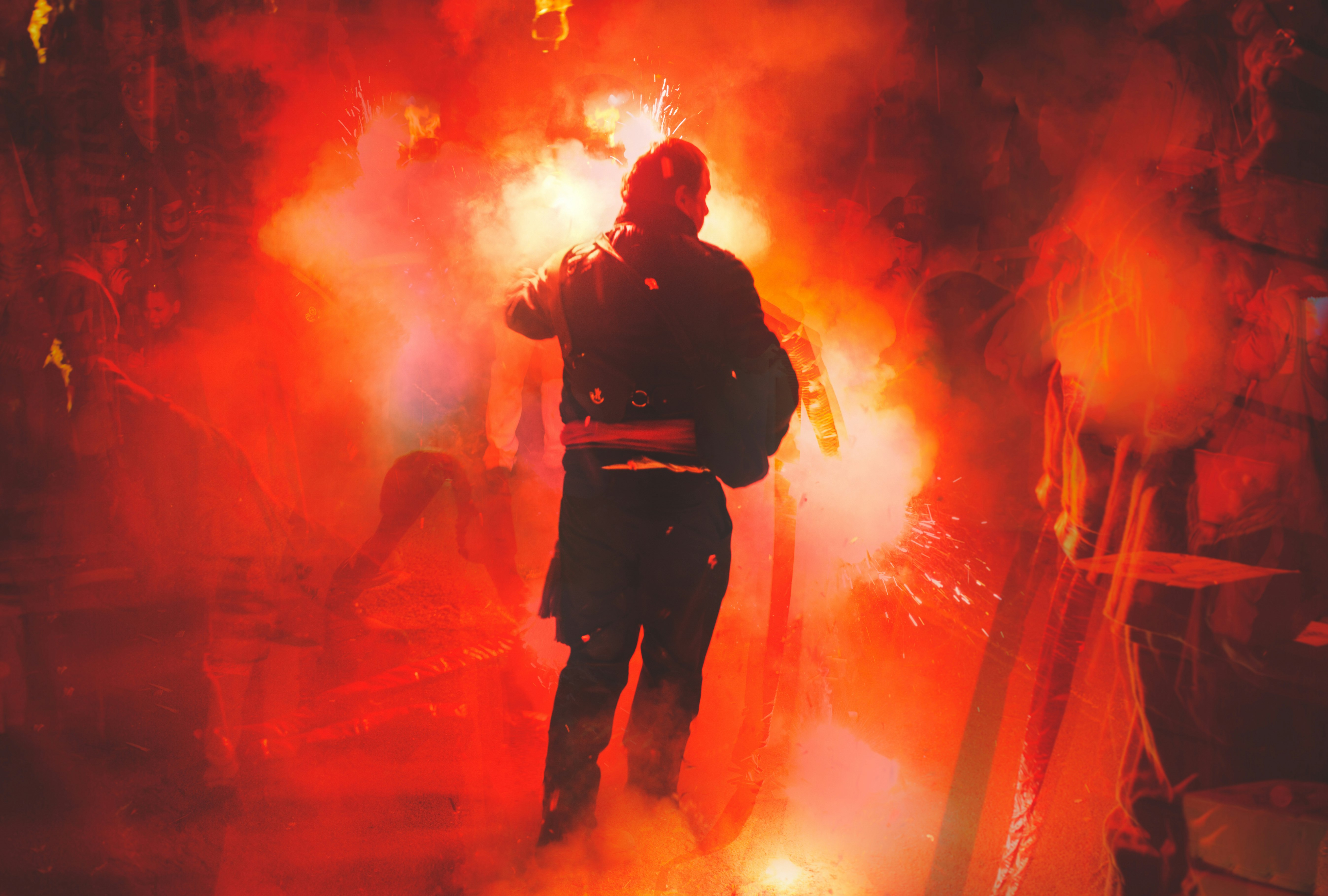 man in black jacket standing on stage with red lights